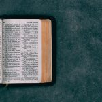 open pocket bible on green surface