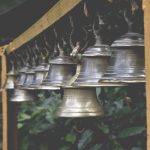 silver bell hanging on black metal bar